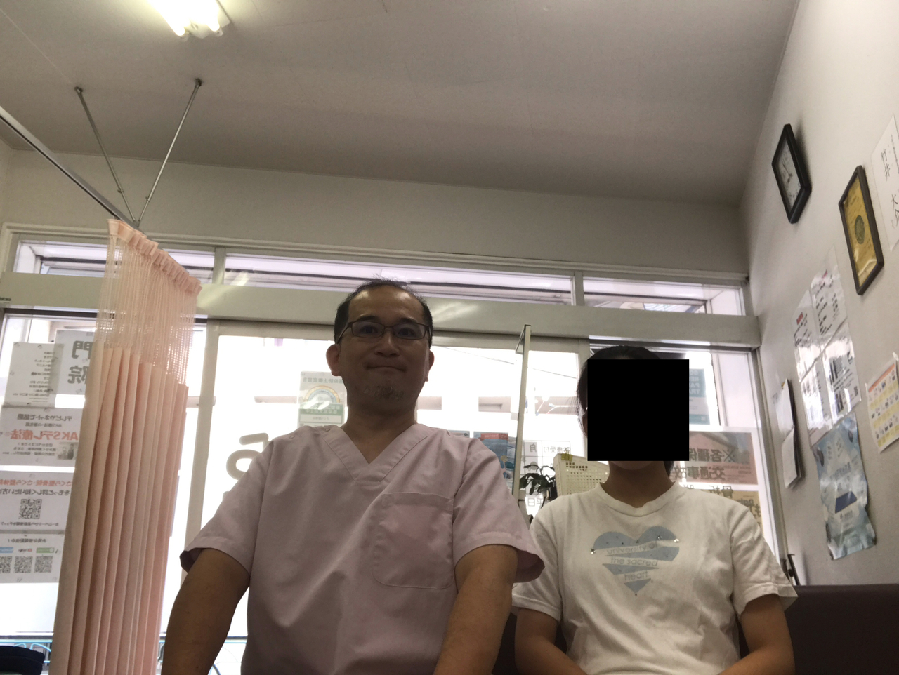 首の痛みを施術で改善させた女子中学生と整体師が並んで笑顔を見せるツーショット写真