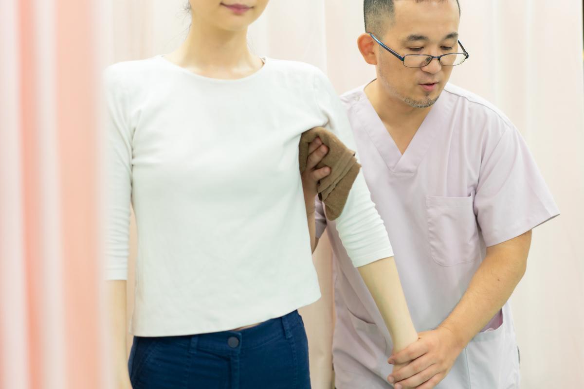 五十肩の状態を確認するため、肩関節の動きや痛みの有無を丁寧に検査している様子