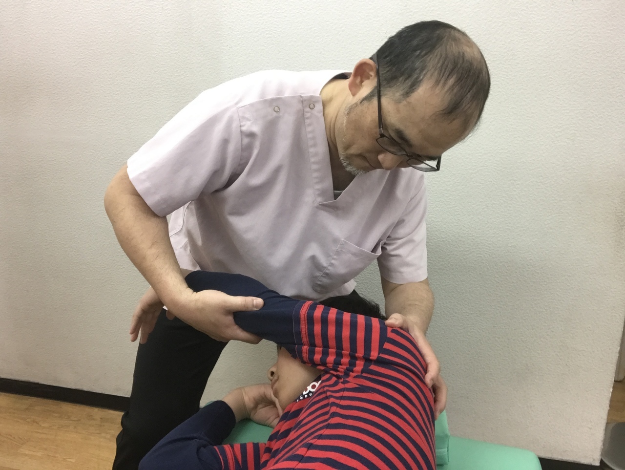 さくら整骨院の竹井大介が子供に優しい施術をしている写真
